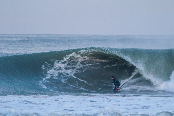 Surfista profesional midiendo parámetros de una ola en la costa peruana